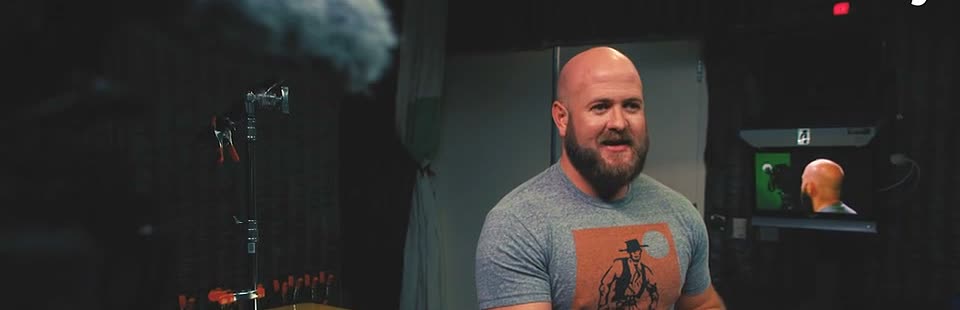 Mitchell Williams between takes on the AJ+ studio set, teleprompter and boom mic in frame